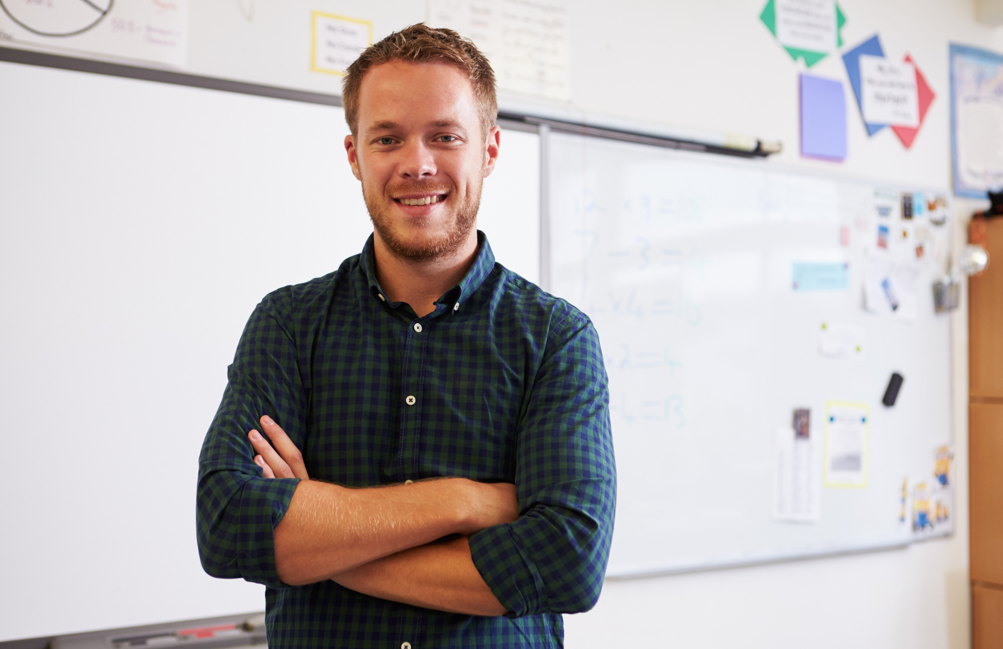 Photo of white man standing in front of a classroom whiteboard